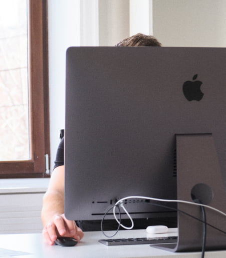 A picture of a person sitting at a computer.